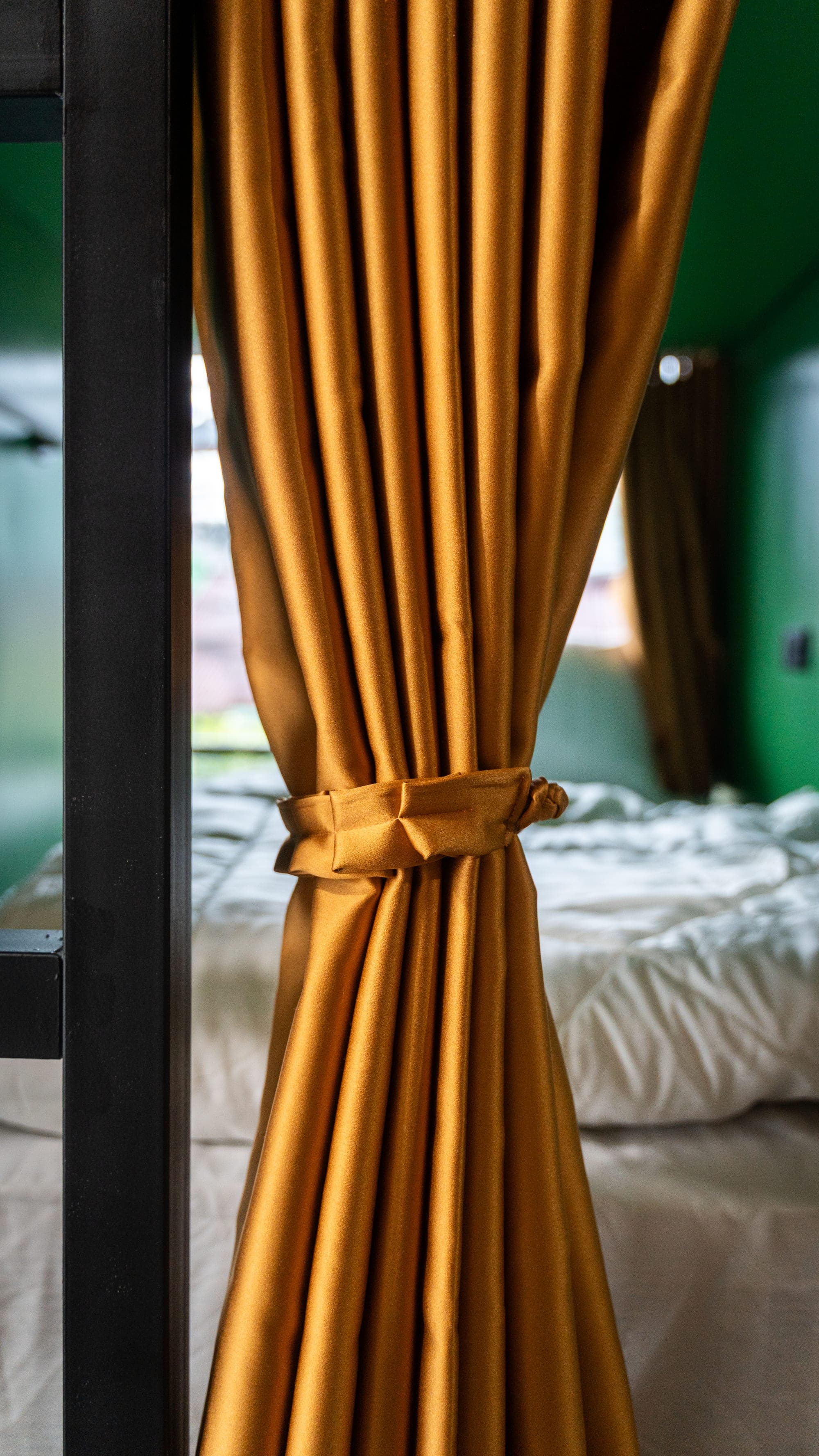 Gold privacy curtain tied back on a bunk